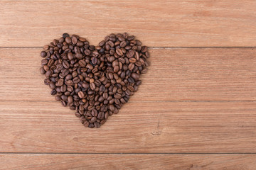 Heart of coffee, heart shape by various of coffee beans on the wooden table