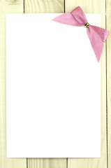 White card with pink ribbon, pink bow.