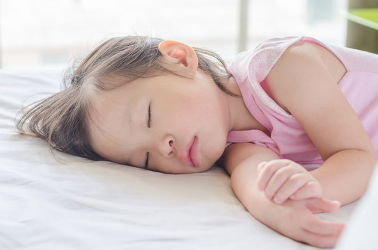 Little Asian girl sleeping on bed at day time