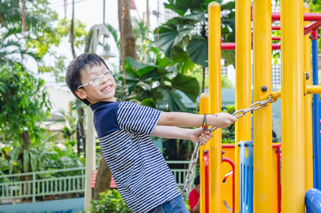 Obraz premium Young asian boy plays at playground