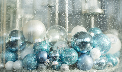blue, turquoise and white christmas balls in a decorative glass