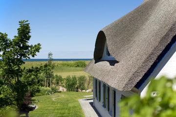 historical house with thatched roof and blue sky at the German Baltic Sea coast, Germany, Europe