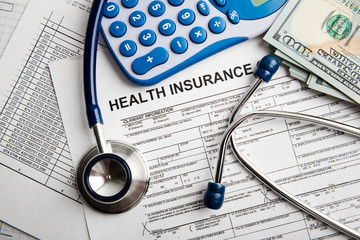 Health insurance application form with banknote and stethoscope