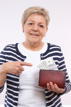 Happy senior female showing dollar currencies in wallet, concept of financial security in old age