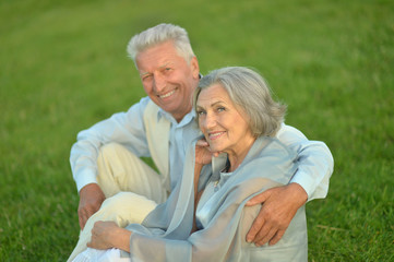 Elderly couple sitting on grass