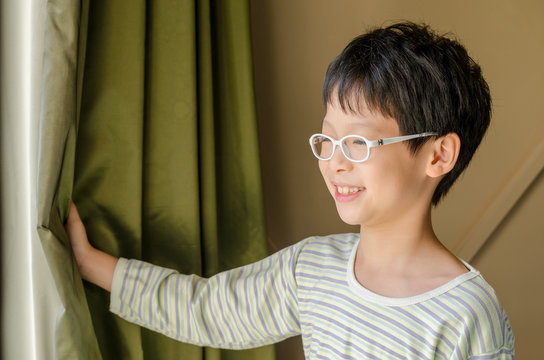 Young Asian Boy Open Curtain And Smile