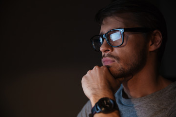 Closeup of focused man in glasses looking at screen