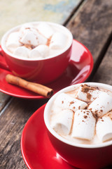 Two red cups of hot chocolate or cocoa on the table