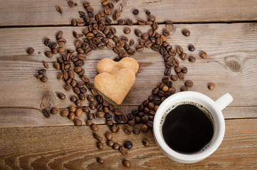 The cup of coffe and Frame- heart from coffee beans and two cook