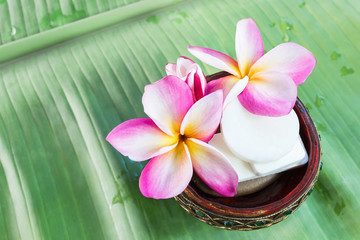 Obraz na płótnie Canvas Mini set of shower bath soap with flowers frangipani on green ba
