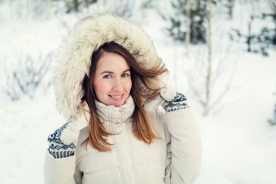 Christmas girl outdoor portrait. Woman in winter clothes on a snow field. Toned picture