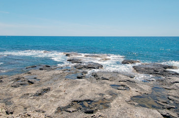 Fototapeta na wymiar Rock sea shore with blue sky