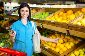 Portrait of a smiling woman picking orange