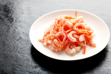 Fresh boiled shrimps on a black wooden table