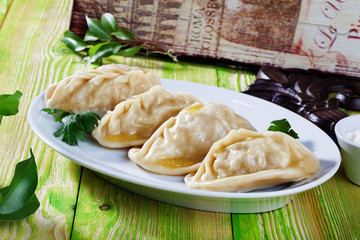 manti ravioli large dumplings plate with sour cream and dill Still, board, green, beautiful