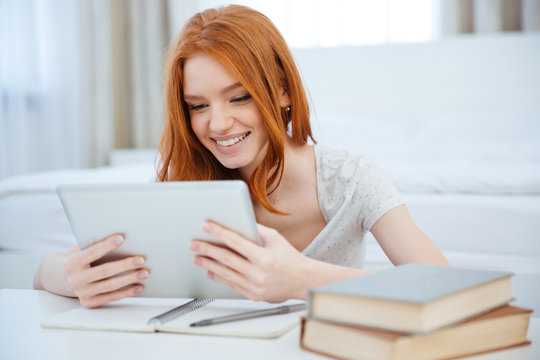 Redhead woman sitting at the table with her homework