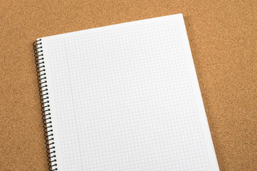 White notebook with square on cork board
