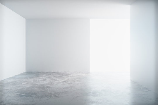 Empty white room with a concrete floor and blank wall with copys