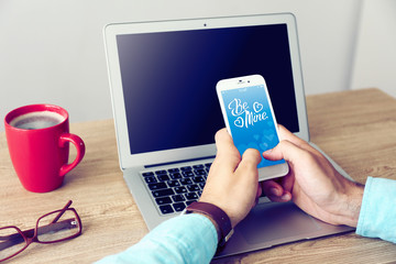 Man using mobile phone with romantic screensaver in office