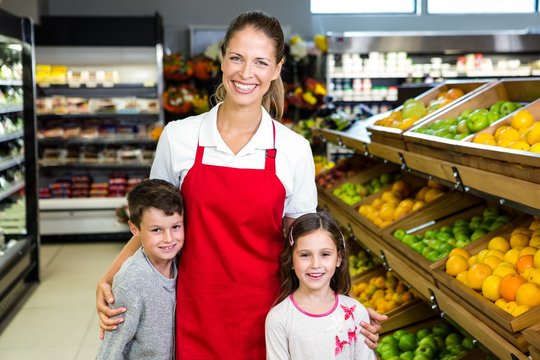 Female worker with two kids in grocery store 