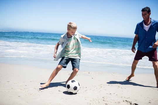 Fototapeta Father and son playing soccer