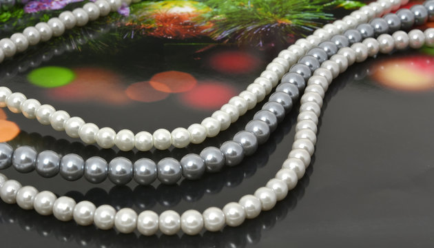 Strings of pearl beads on dark background