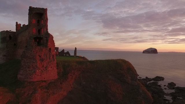 Stunning aerial shot Tantallon Castle off the coast of North Berick, Scotland with Bass rock in the background
