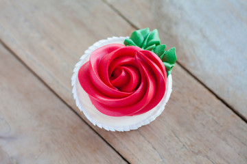 red rose cupcake on wooden table