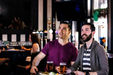 Friends having a pint and watching tv