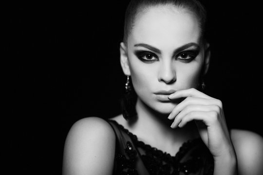 Hot young woman model with sexy lips makeup, strong eyebrows, clean shiny skin. Beautiful fashion portrait of glamour female face. Black and white photo