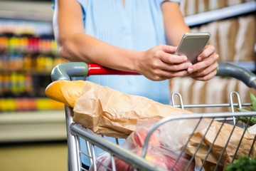 Woman using her smartphone in aisle