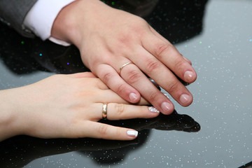 bride and groom show their hands wearing wedding rings