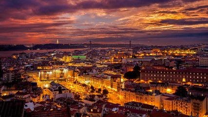 Fototapeta na wymiar Strahlender Sonnenuntergang ueber Lissabon mit Strassenbeleuchtung