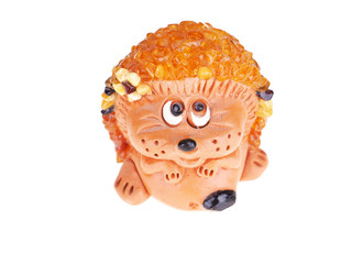 Toy hedgehog made of amber on a white background © enskanto