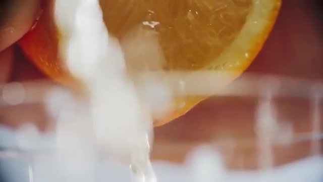 Close up of squeezing orange juice by hand