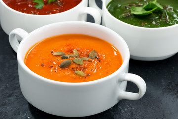 assortment of fresh vegetable soup on a dark background, closeup