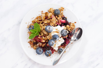 berry crumble with oat flakes on white table, top view, closeup