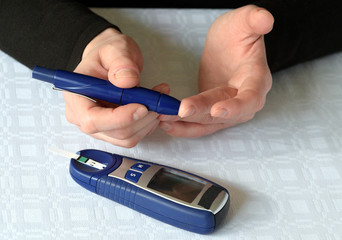 Checking blood glucose level with a glucose meter with blood drop