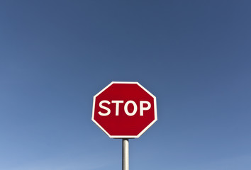 Red stop sign and blue sky.