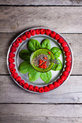 Green smoothies Serve Served on a plate with baby spinach and arranged around the raspberries. Smoothie sprinkled with chia seeds and goji berries.