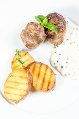 Beautiful juicy grilled meat with fried potatoes on a wooden table