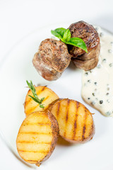 Beautiful juicy grilled meat with fried potatoes on a wooden table