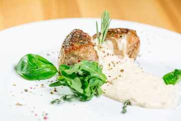 Beautiful juicy grilled meat with garnish on a wooden table