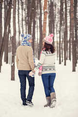 Woman and man are having walk in winter snowy countryside.