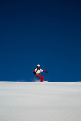 Male skier skiing in fresh snow on ski slope on a sunny winter day at the ski resort in Georgia