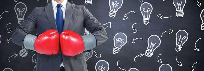Composite image of businessman with boxing gloves