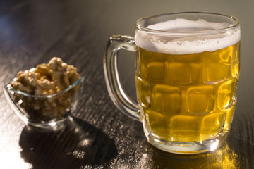beer on the dark black wood near beer nuts