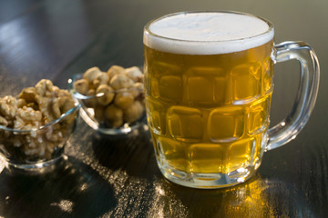 beer on the dark black wood near beer nuts