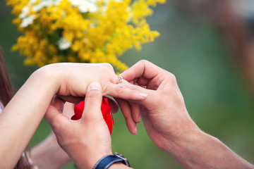 groom dresses a ring on  finger to the bride
