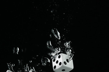 Fototapeta premium Dice falling into water. On a black background.